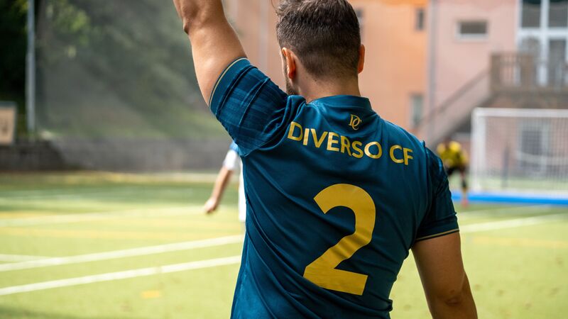 Záda petrolejového dresu se zlatým nápisem DIVERSO CF a číslem 2